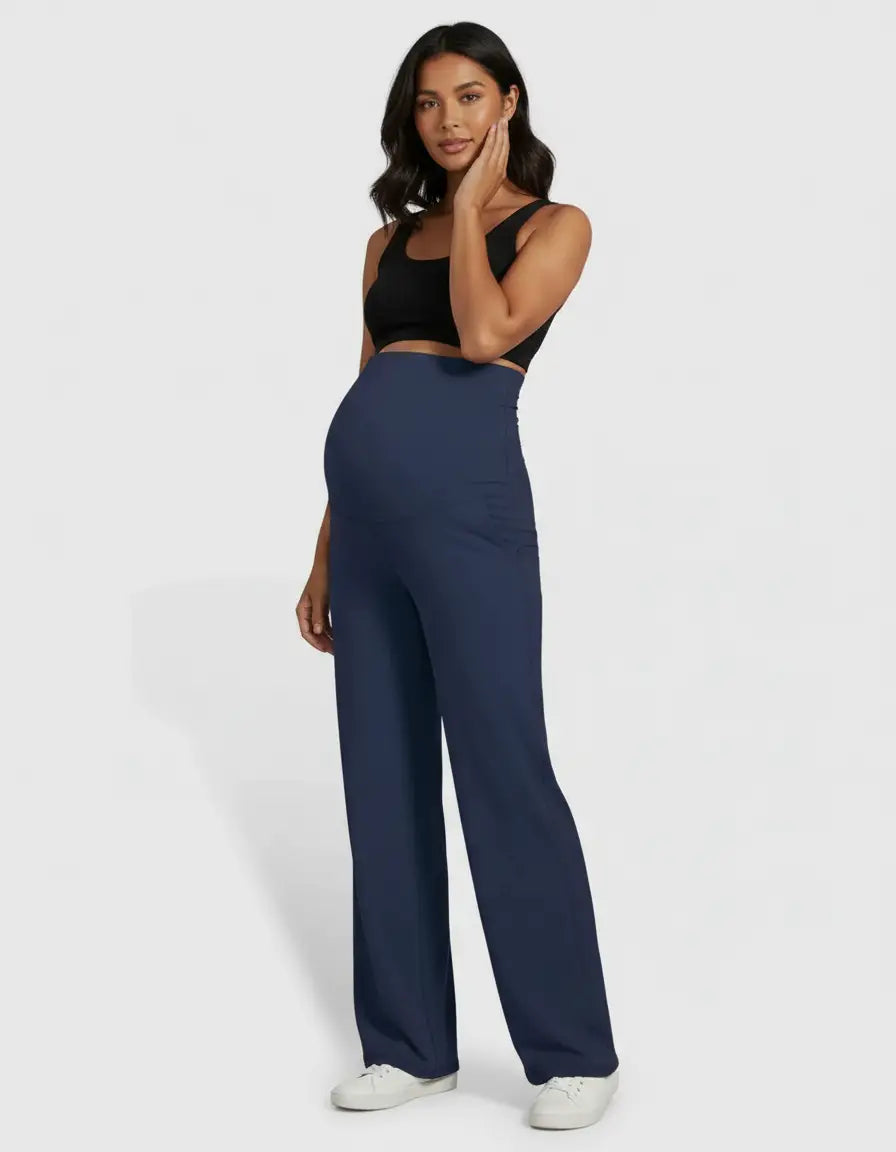 Pregnant woman in navy high-waist straight-leg maternity pants and a black crop top.