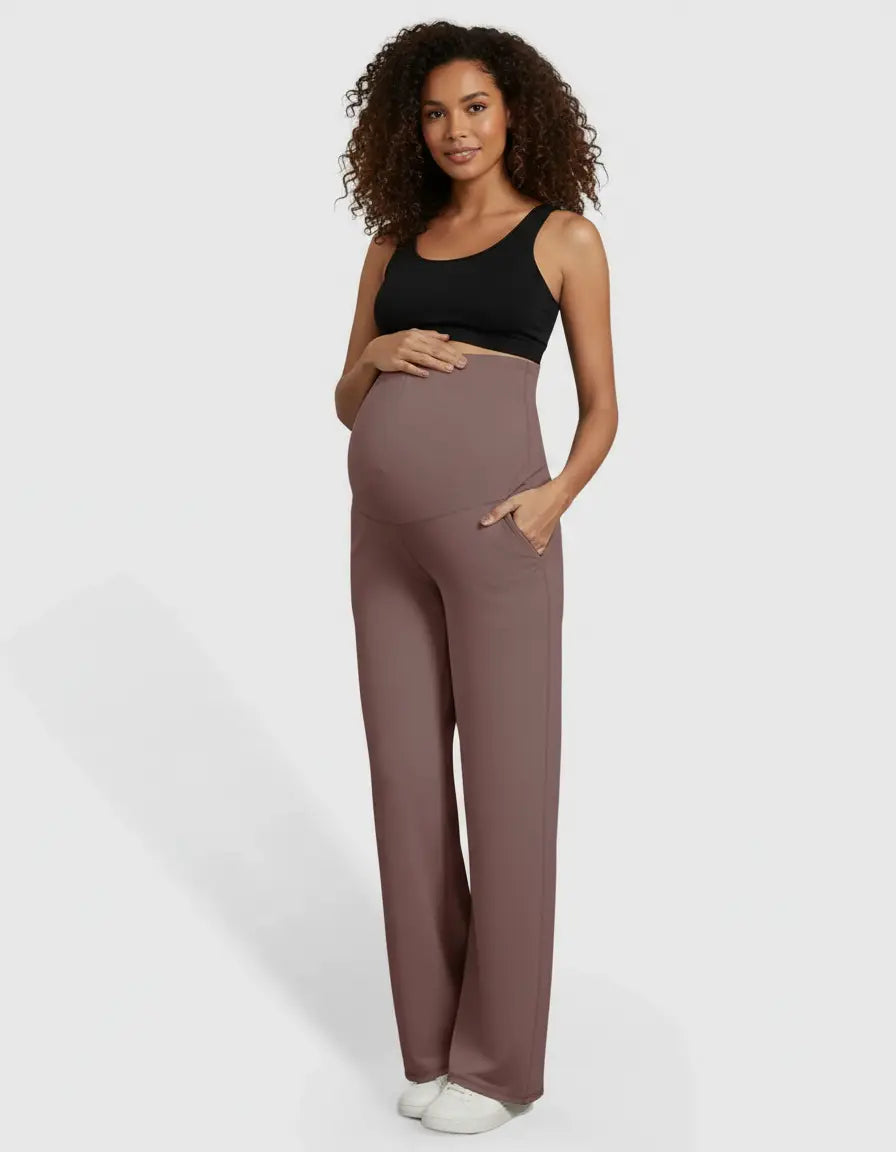 Smiling pregnant woman in a black bra and comfortable mauve high-waist straight-leg maternity pants with pockets.