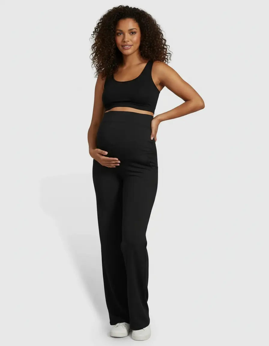 Pregnant woman in black high-waist straight-leg maternity pants and a matching crop top.
