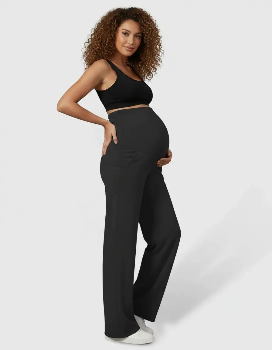 Pregnant woman in black high-waist straight-leg maternity pants and a black crop top.