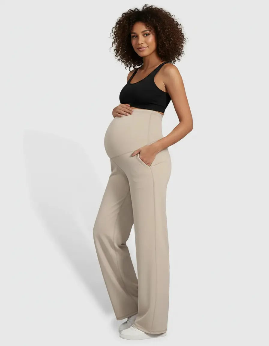 Pregnant woman in beige high-waist straight-leg maternity pants with pockets and a black top.