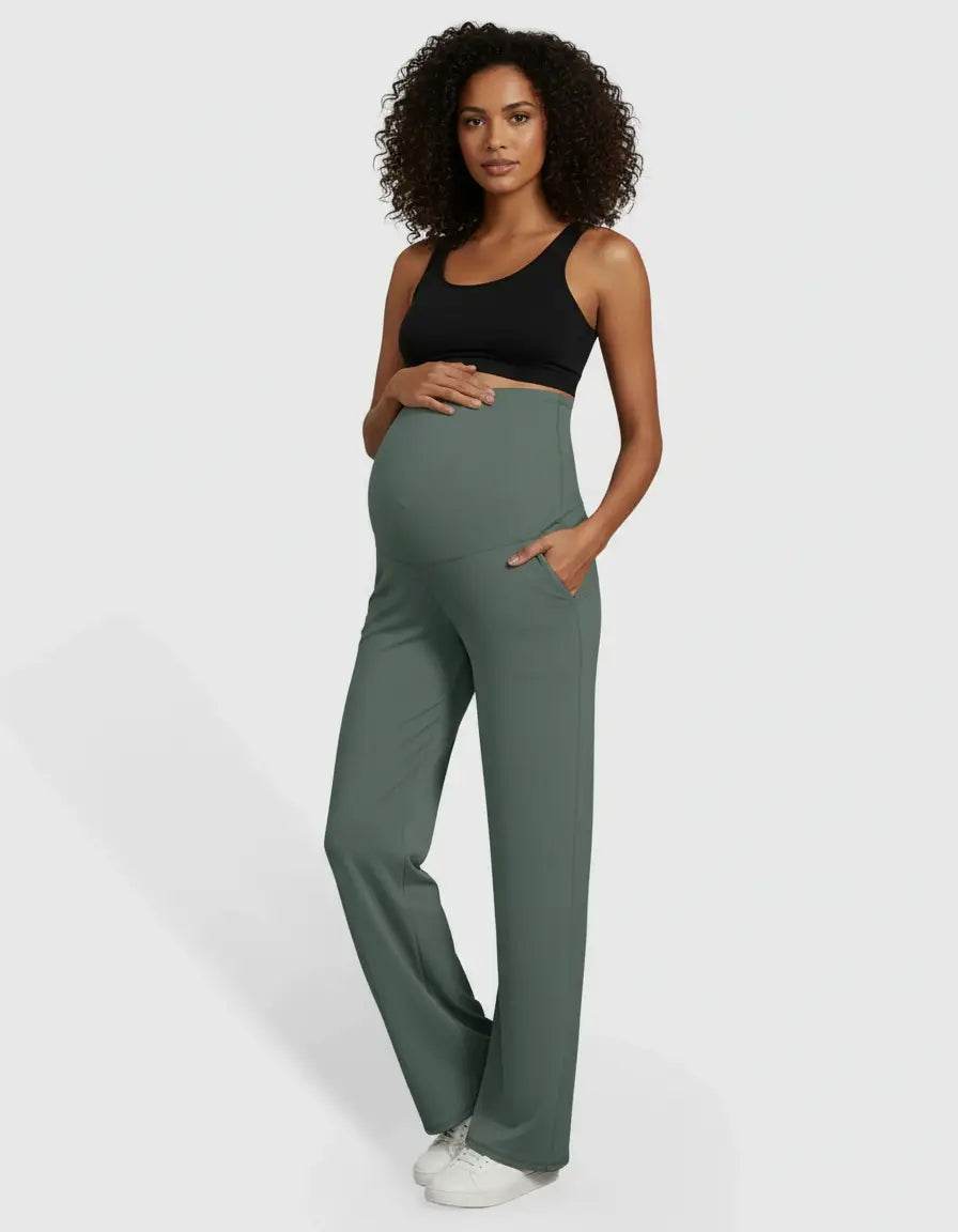 Pregnant woman in olive green high-waist straight-leg maternity pants with pockets and a black sports bra.