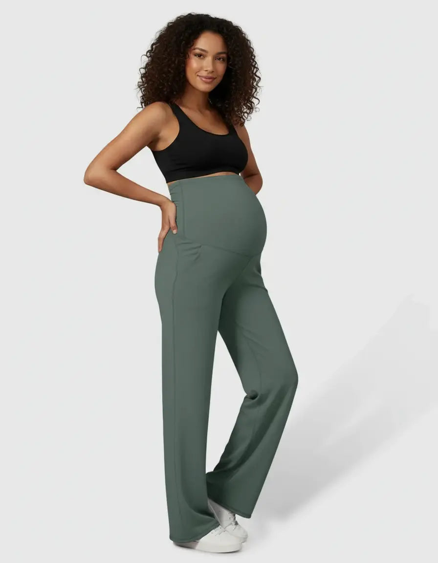 Pregnant woman in sage green high-waist straight-leg maternity pants and a black sports bra.