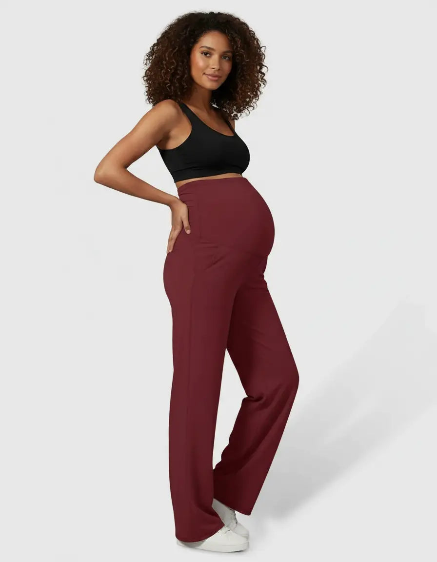 Pregnant woman in high-waist, straight-leg burgundy maternity pants and a black bra top.