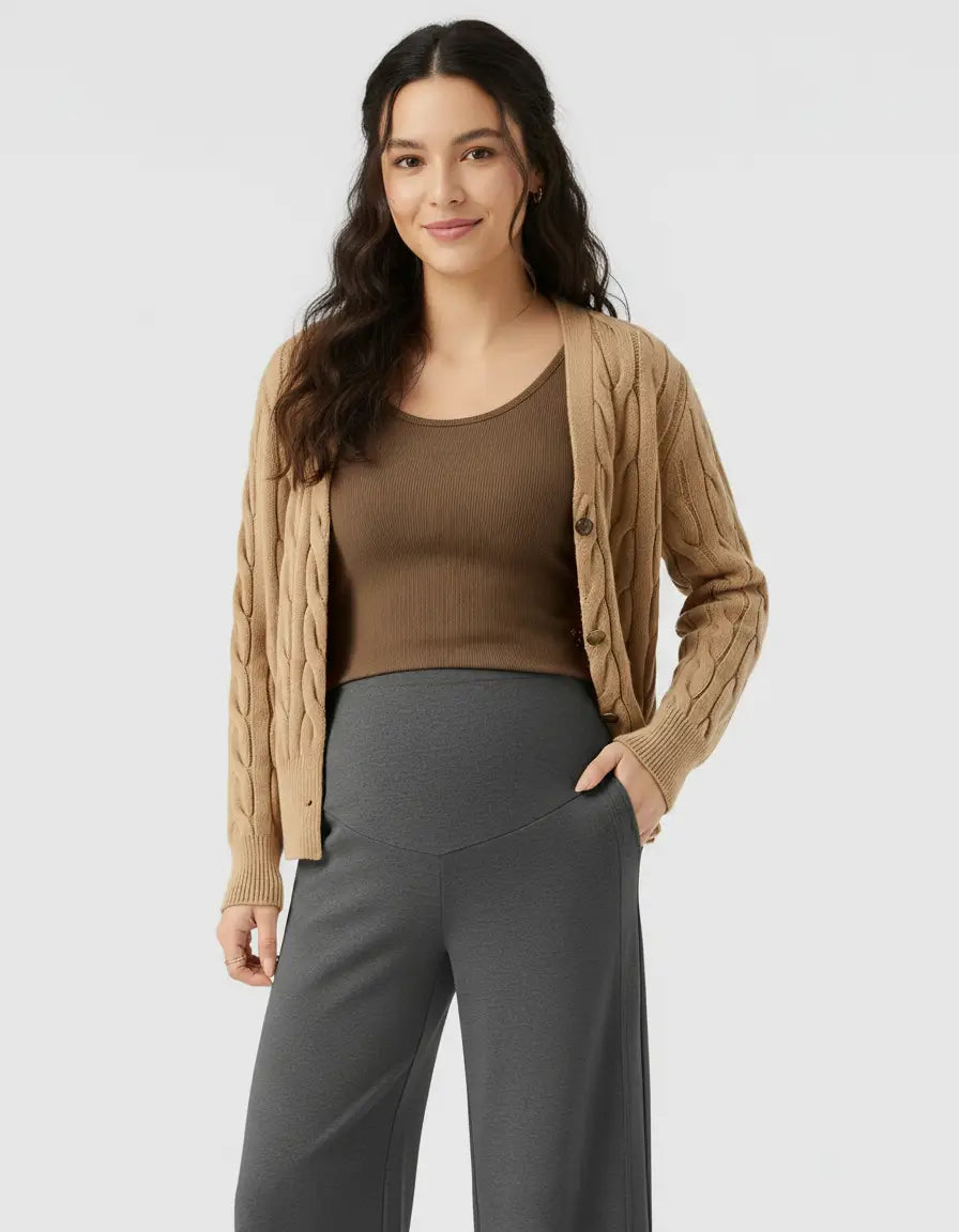 Smiling pregnant woman in charcoal high-waist wide-leg maternity wool pants and a brown top.