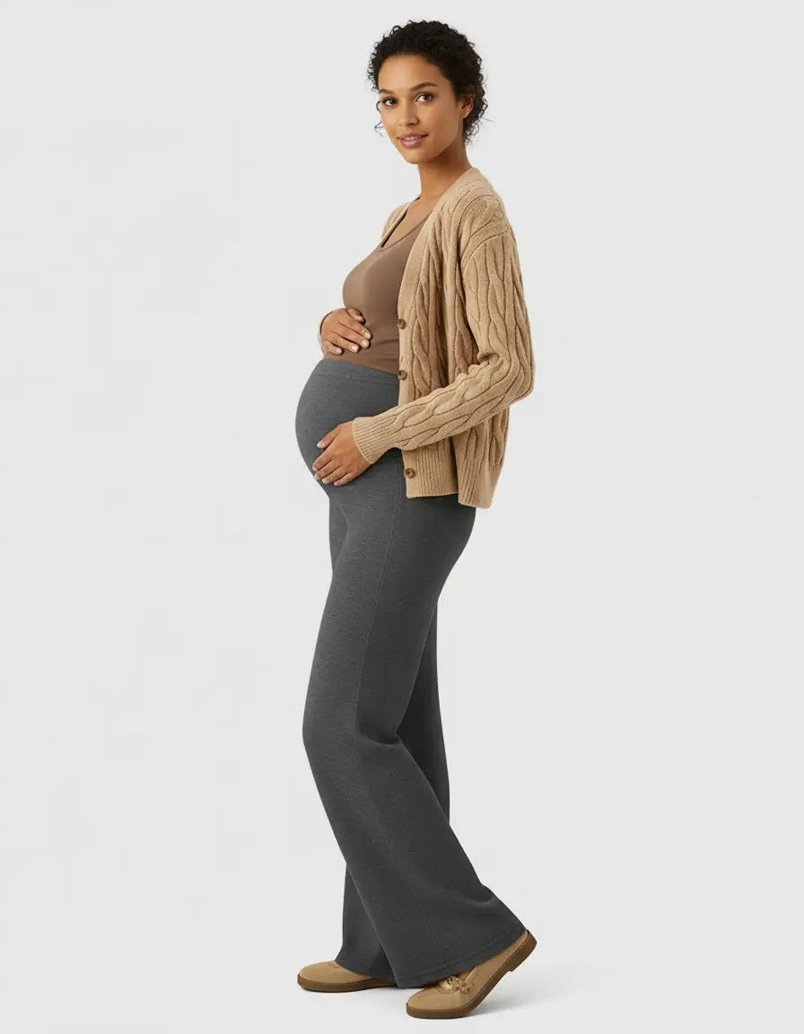 Pregnant woman in charcoal gray high-waist wide-leg maternity wool pants, brown top, and beige cardigan.