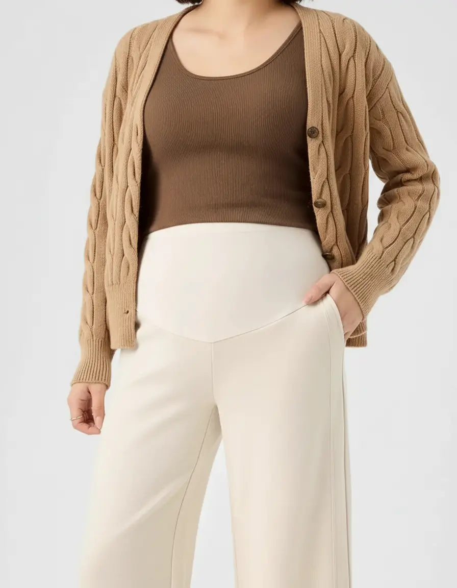Trendy high-waist wide-leg maternity wool pants in cream, paired with a brown tank top and cardigan.