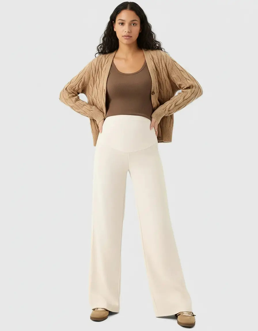 Model wearing cream high-waist wide-leg maternity wool pants with a brown tank top and cardigan.