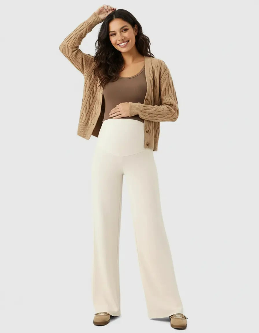 Smiling pregnant woman in cream high-waist wide-leg maternity wool pants and a brown cardigan.