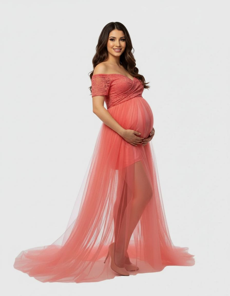 Smiling pregnant woman in a coral lace and mesh off-shoulder maternity gown with a flowing skirt.
