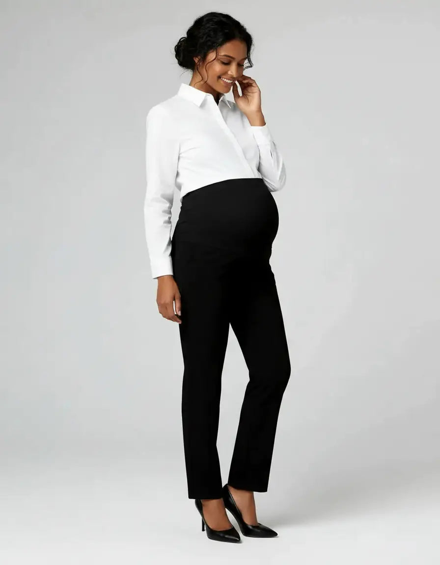Smiling pregnant woman in black mid-waist straight-leg maternity work pants and a white shirt.