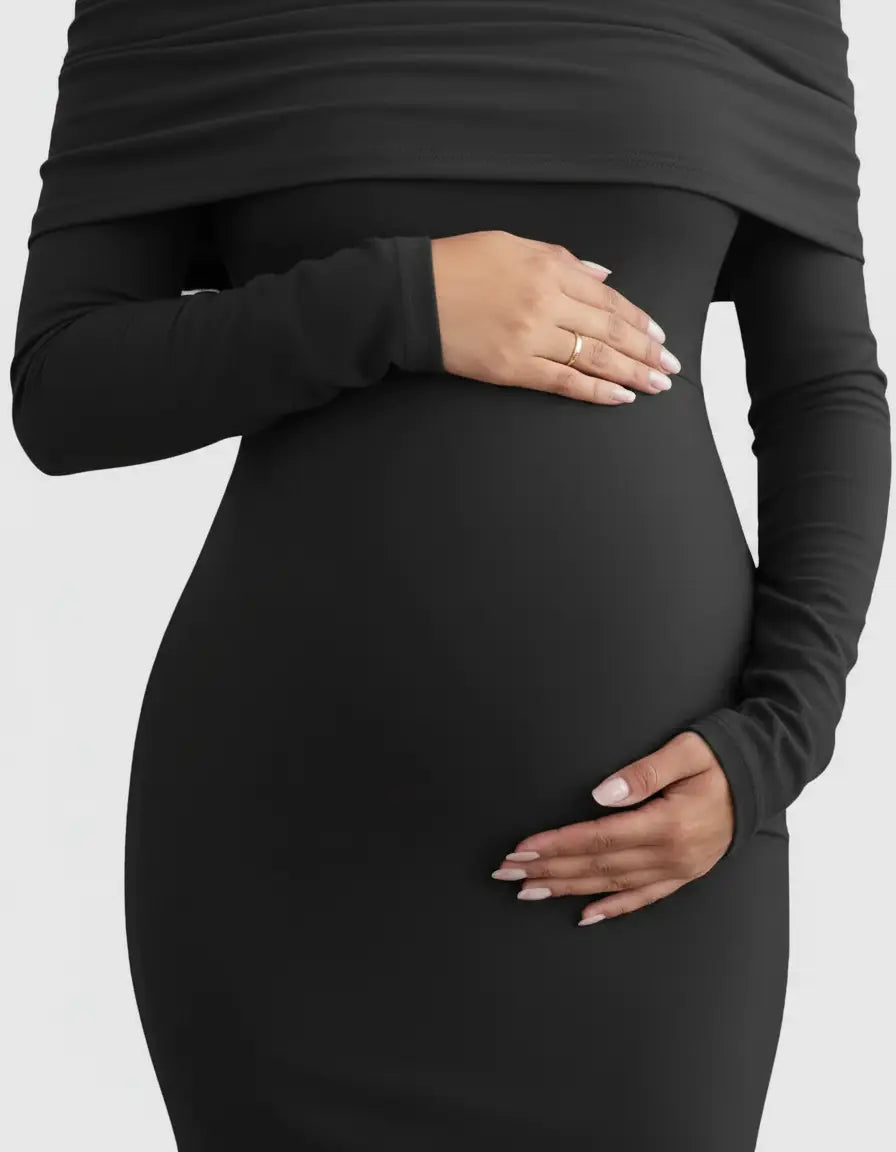 Black off-shoulder cross-back maternity gown with long sleeves, highlighting a pregnant belly.