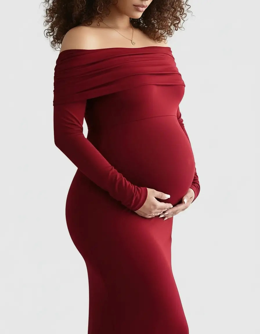 Pregnant woman in a long-sleeve, off-shoulder, cross-back, form-fitting red maternity gown.