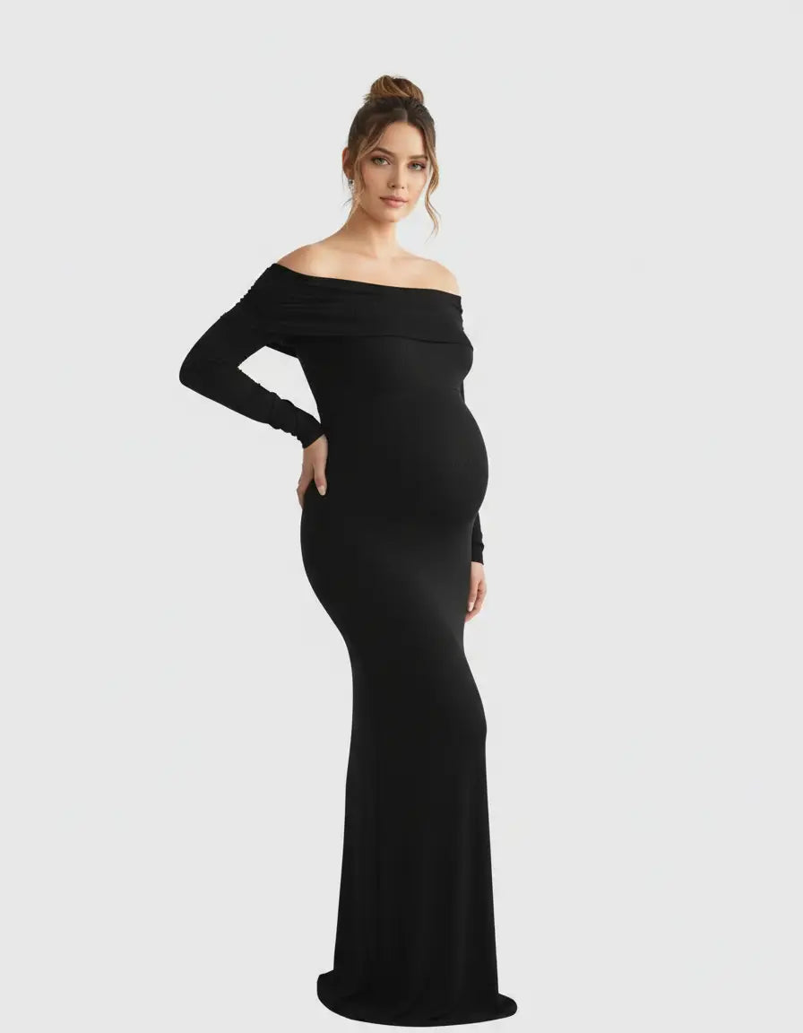 Pregnant woman in a black off-shoulder, long-sleeve, cross-back maternity gown.