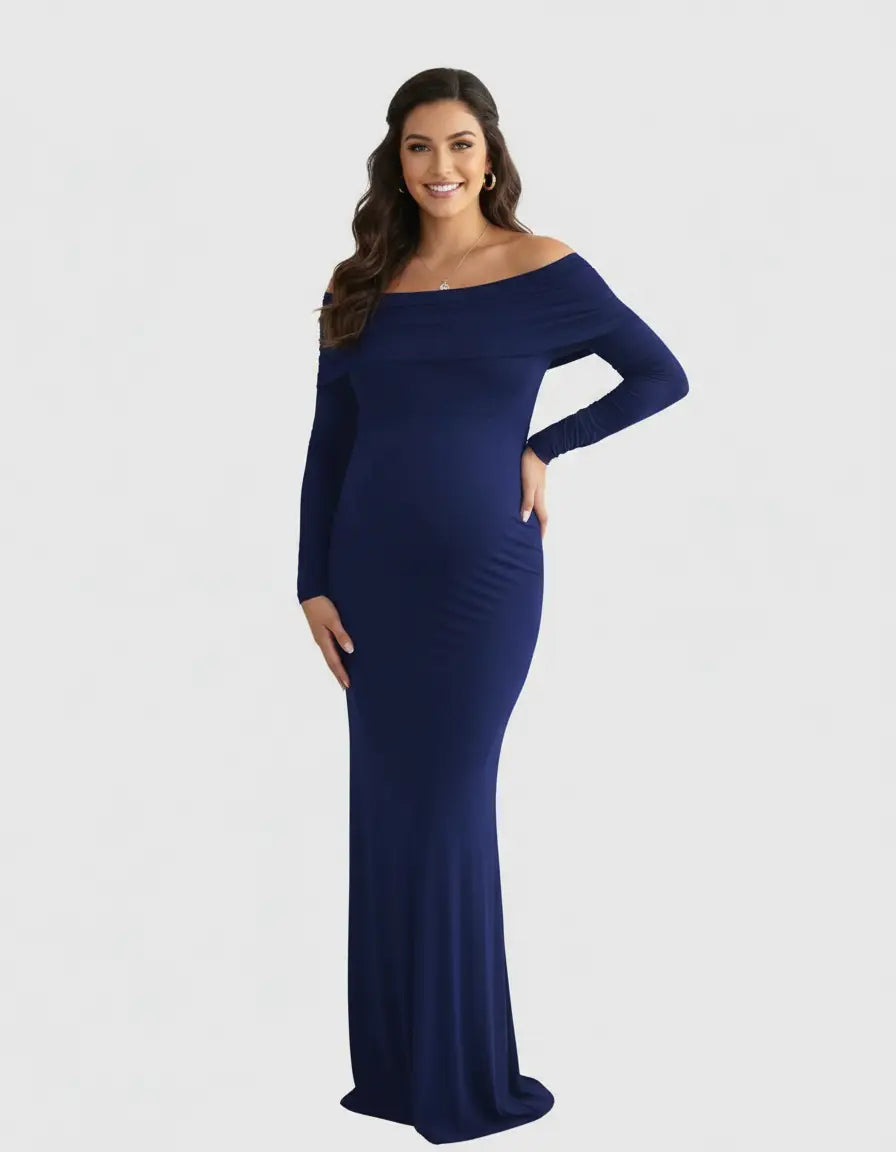 Smiling pregnant woman in a navy off-shoulder, long-sleeve maternity gown.