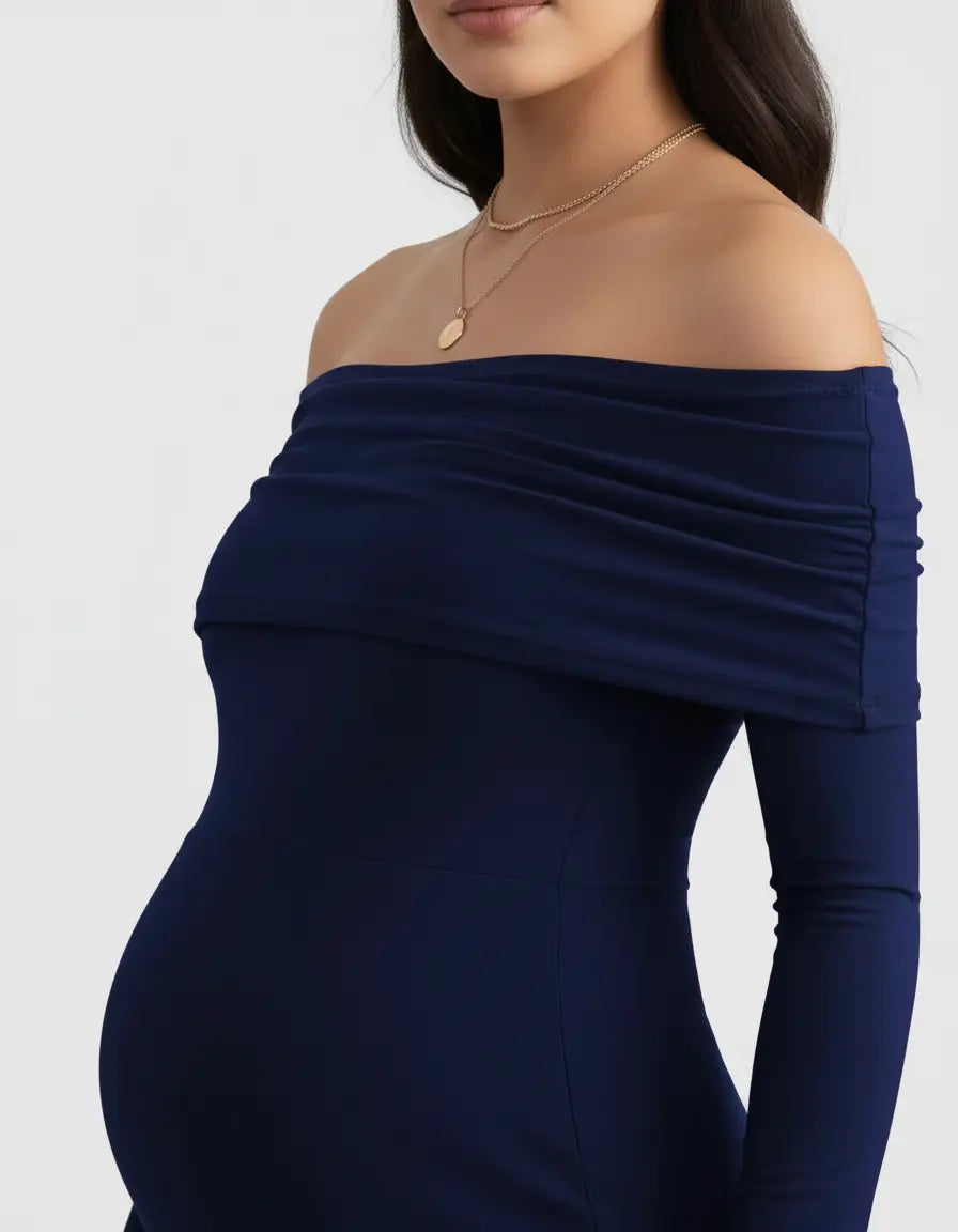 Navy off-shoulder maternity gown with long sleeves and ruched detailing, worn by a pregnant woman.
