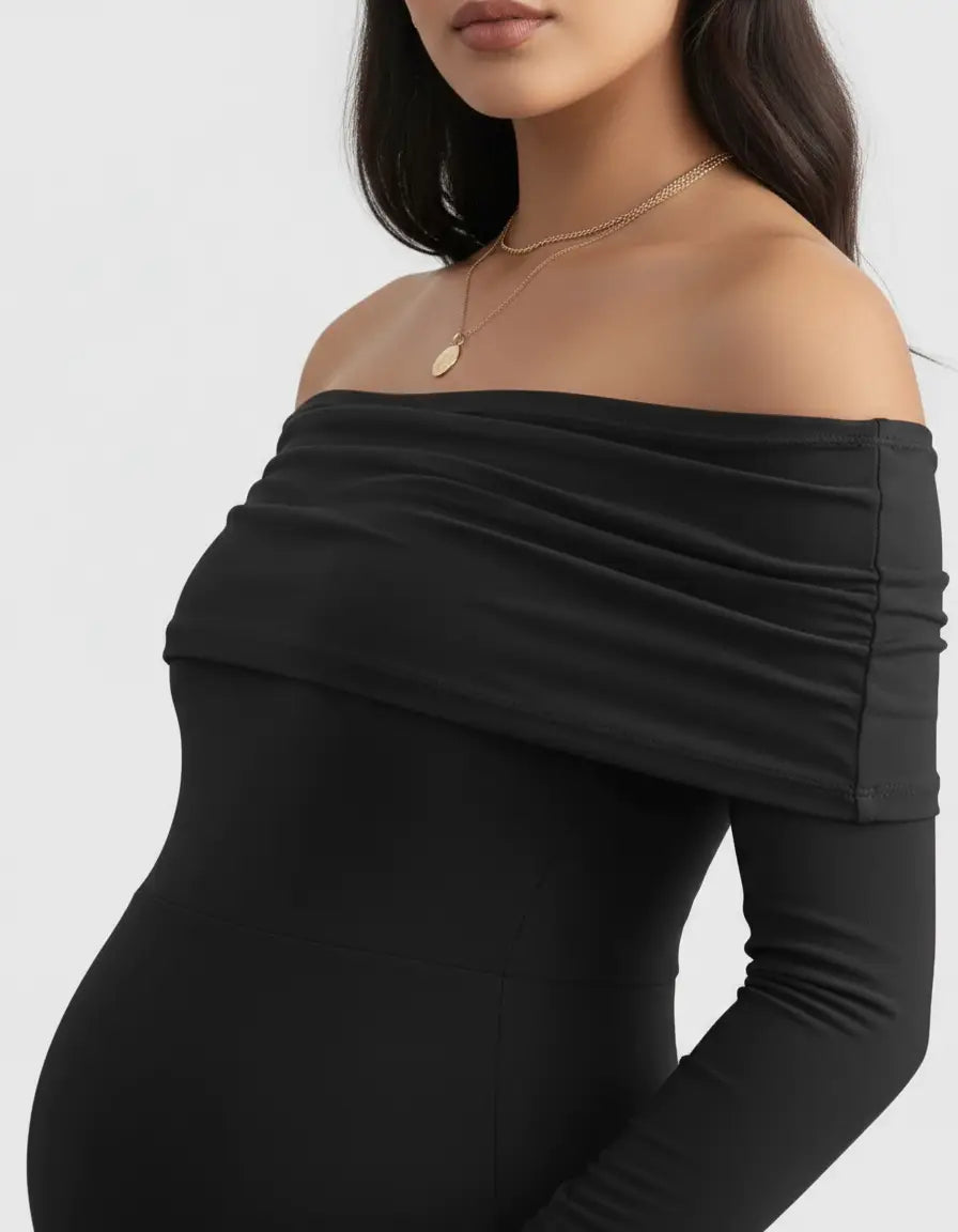 Black off-shoulder cross-back maternity gown with long sleeves and a gold pendant necklace.