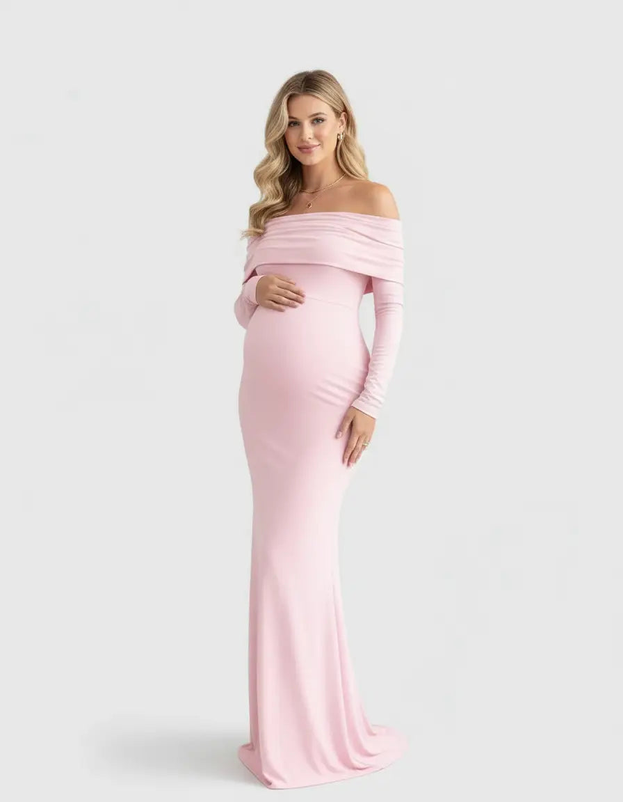 Blonde pregnant woman in a pink off-shoulder cross-back maternity gown.