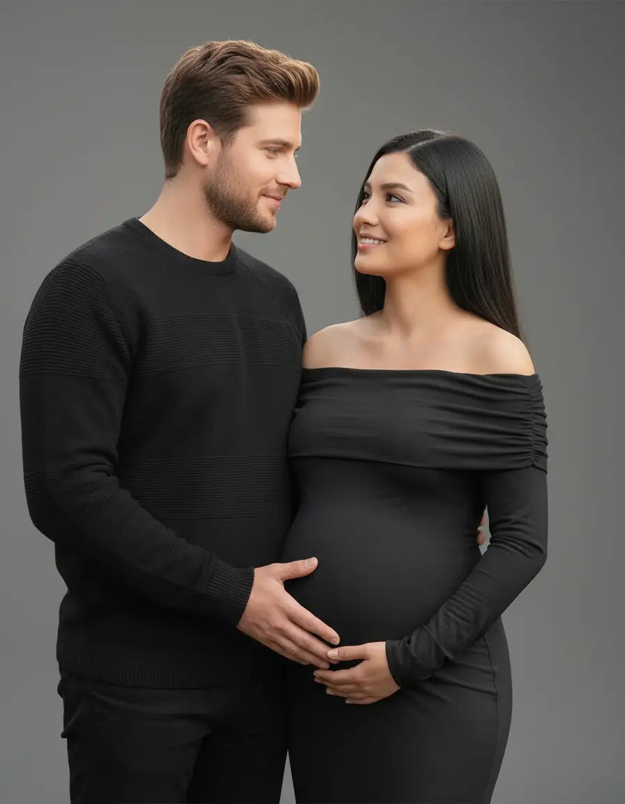 Pregnant woman in black off-shoulder cross-back maternity gown with partner.