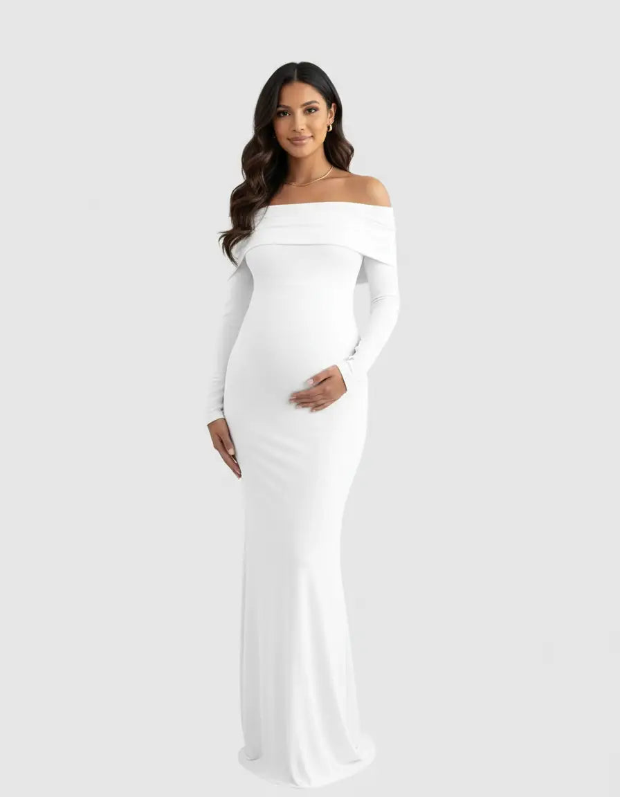Pregnant woman in a white off-shoulder, long-sleeve, cross-back maternity gown.