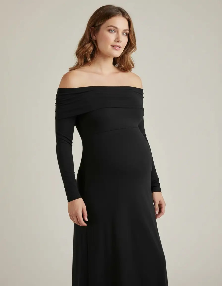 Pregnant woman in a black off-shoulder cross-back maternity gown with long sleeves.