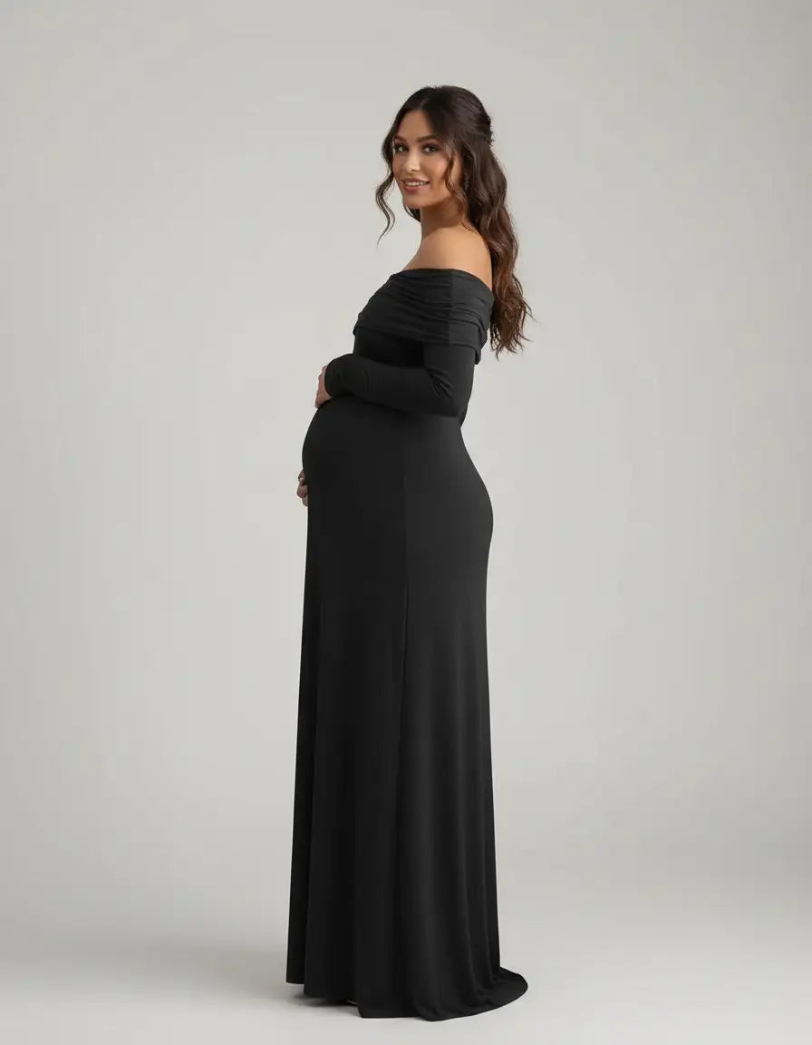 Pregnant woman in a black off-shoulder, long-sleeve, cross-back maternity gown.