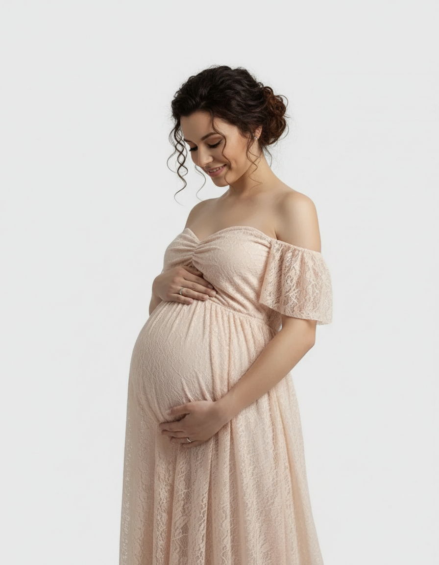 Pregnant woman in a flowing, off-shoulder peach lace maternity maxi dress, gently cradling her belly.