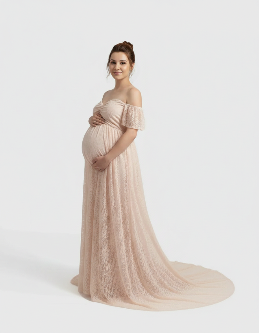 Pregnant woman in a flowing, off-shoulder blush pink lace maternity maxi dress, gently cradling her bump.