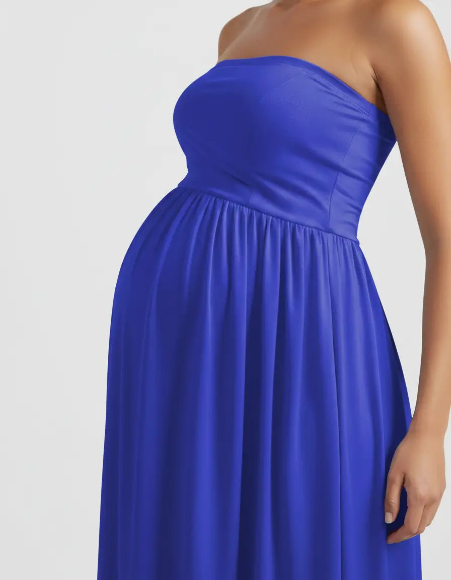 Close-up of a pregnant woman wearing a vibrant blue strapless, flowing maternity photoshoot gown.