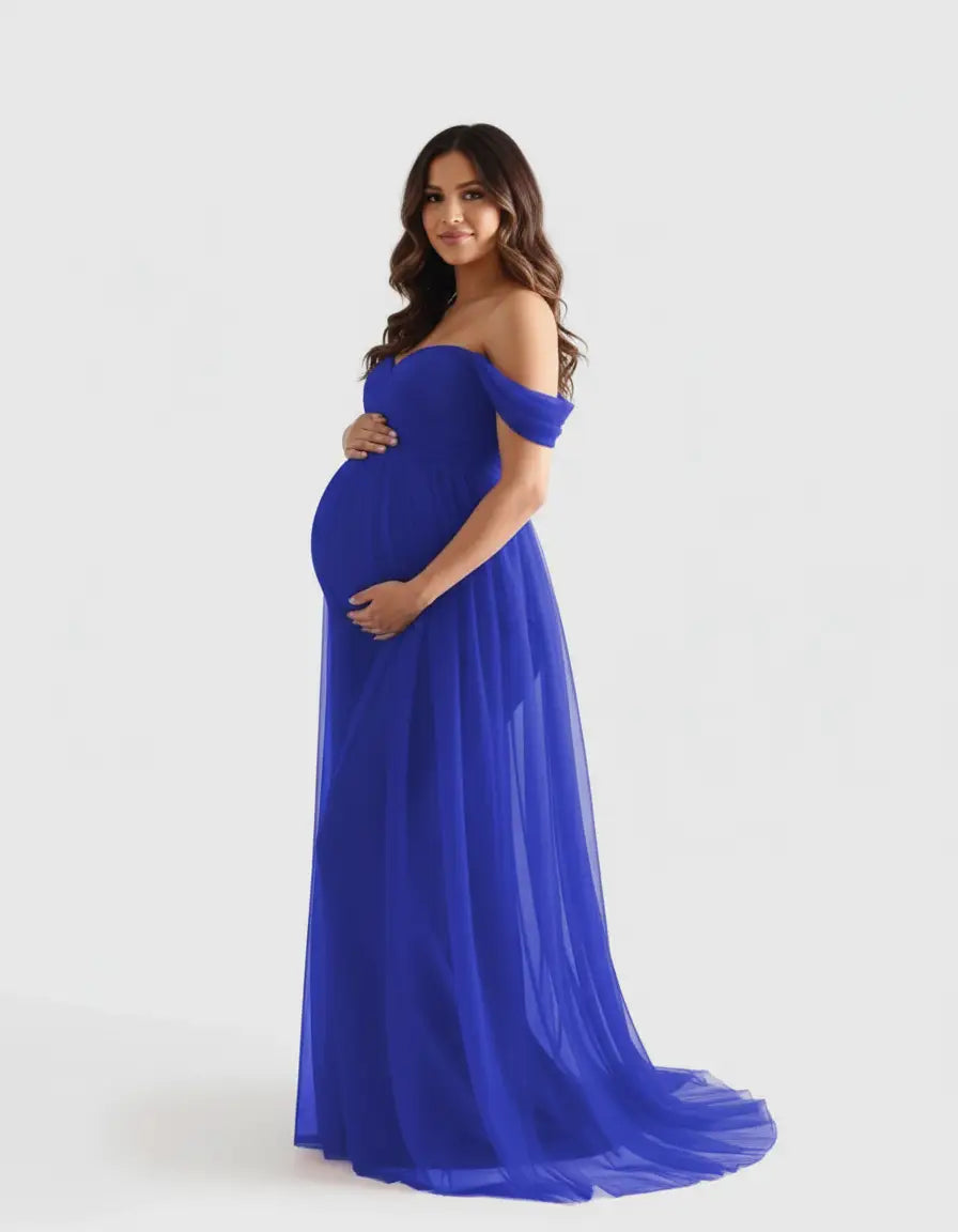 Pregnant woman in a flowing, off-shoulder royal blue maternity photoshoot gown.