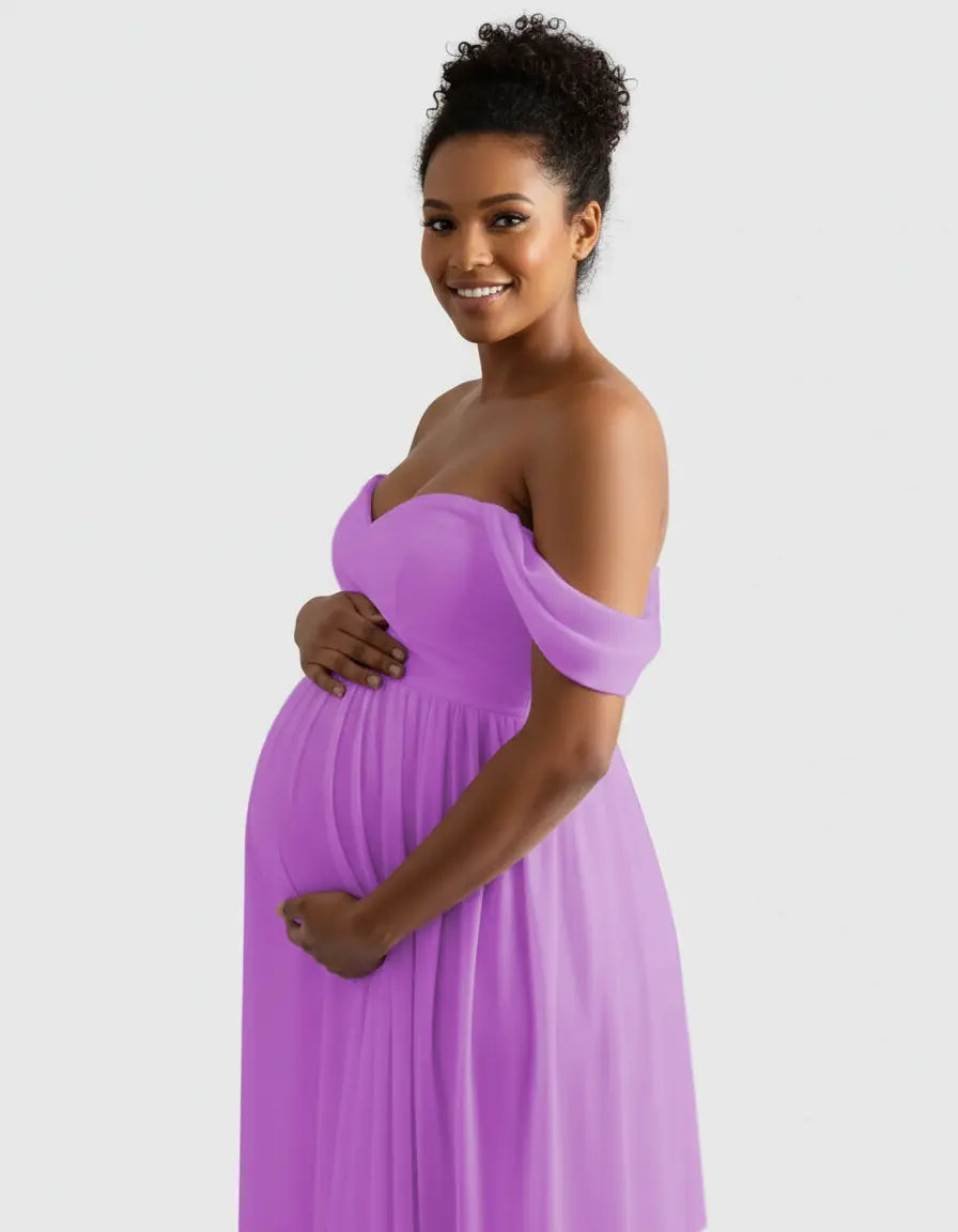 Smiling pregnant woman in a flowing, off-shoulder lavender maternity photoshoot gown.