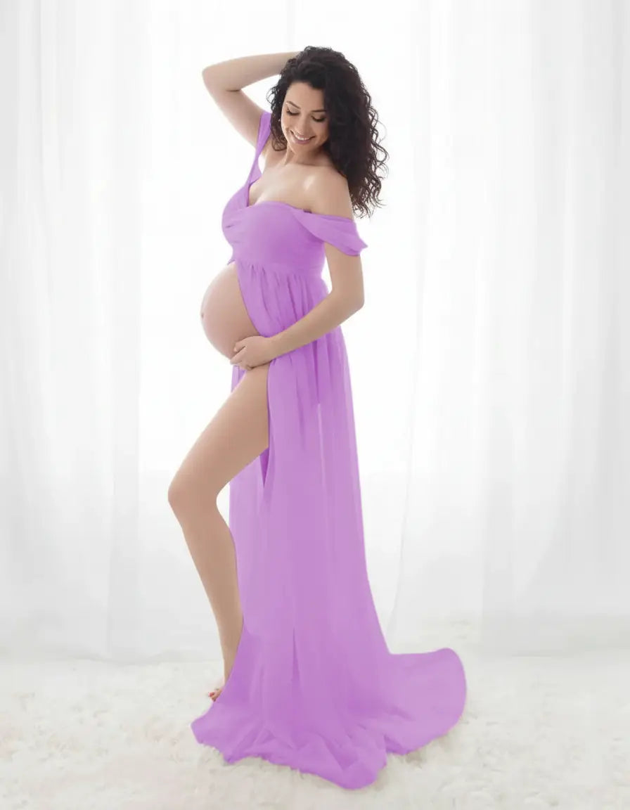 Smiling pregnant woman in a flowing lavender off-shoulder maternity photoshoot gown with a high slit.