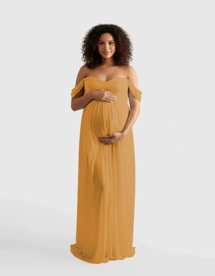 Pregnant woman in a flowing, off-shoulder mustard yellow maternity photoshoot gown.