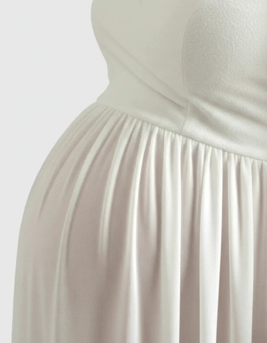 Close-up of a pregnant belly in a flowing white off-shoulder maternity photoshoot gown.