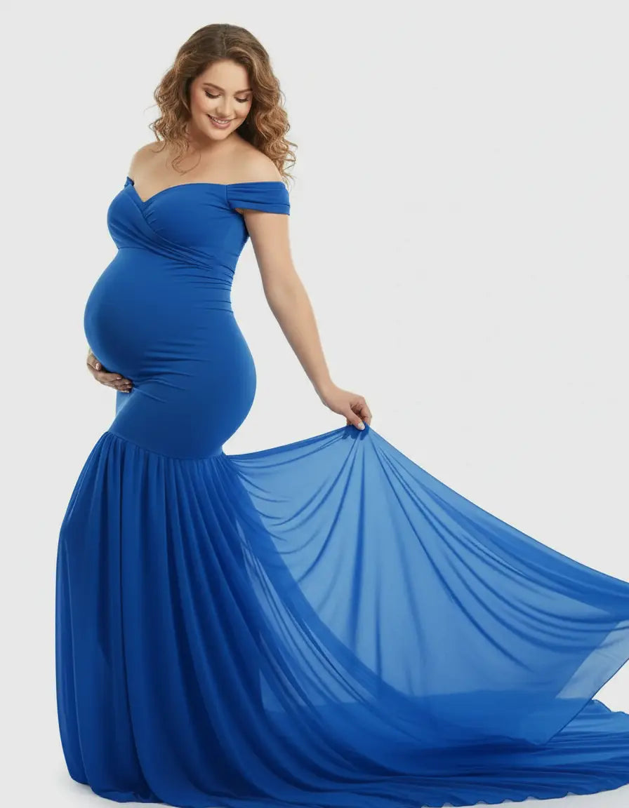 Smiling pregnant woman in a royal blue off-shoulder maternity gown with a fitted bodice and flowy mermaid skirt.