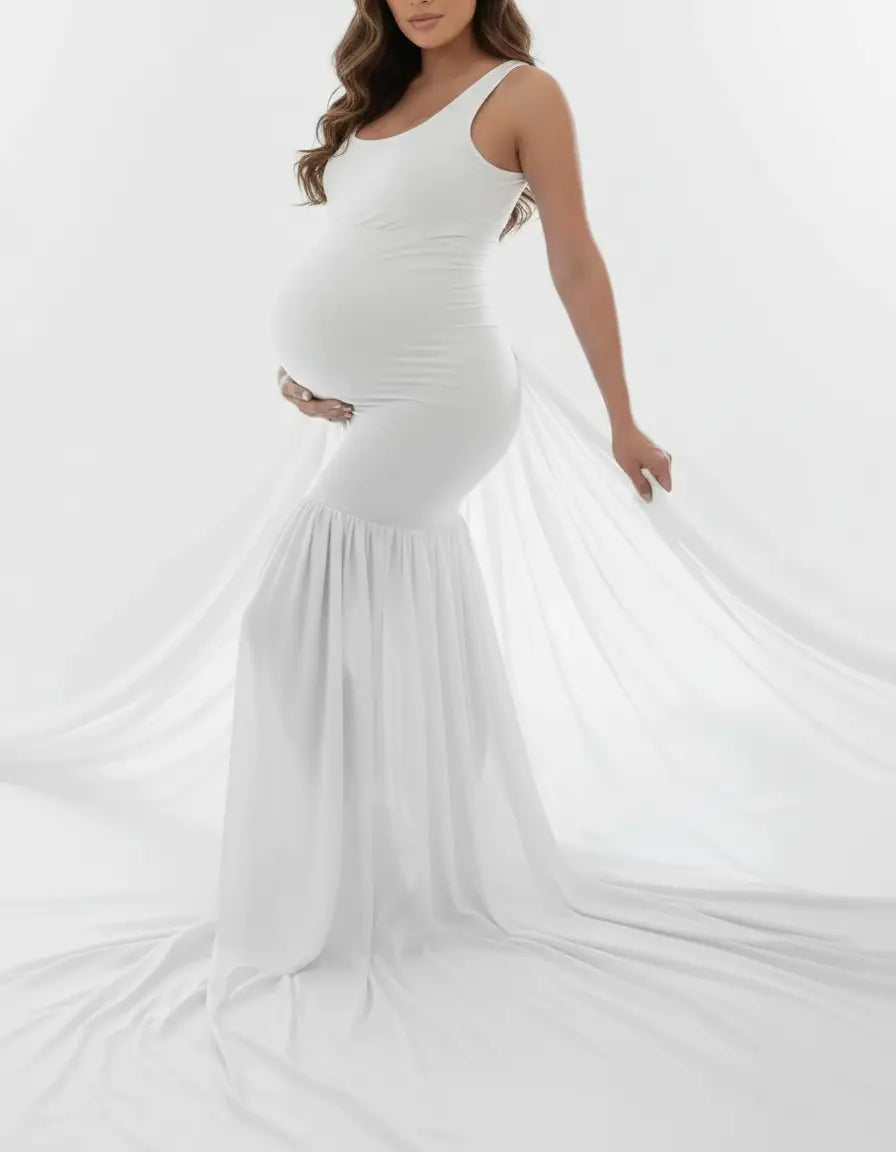 White off-shoulder flowy maternity gown with a fitted bodice and a long, draped skirt.