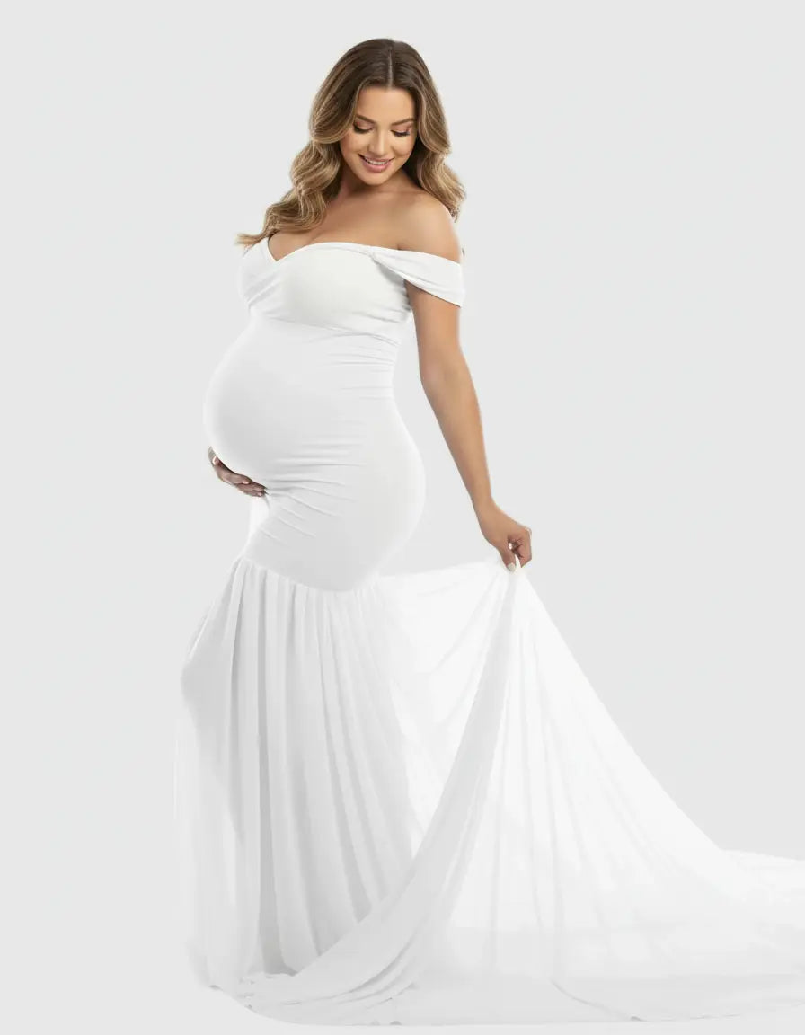 Pregnant woman in a white off-shoulder flowy maternity gown with a mermaid-style skirt.
