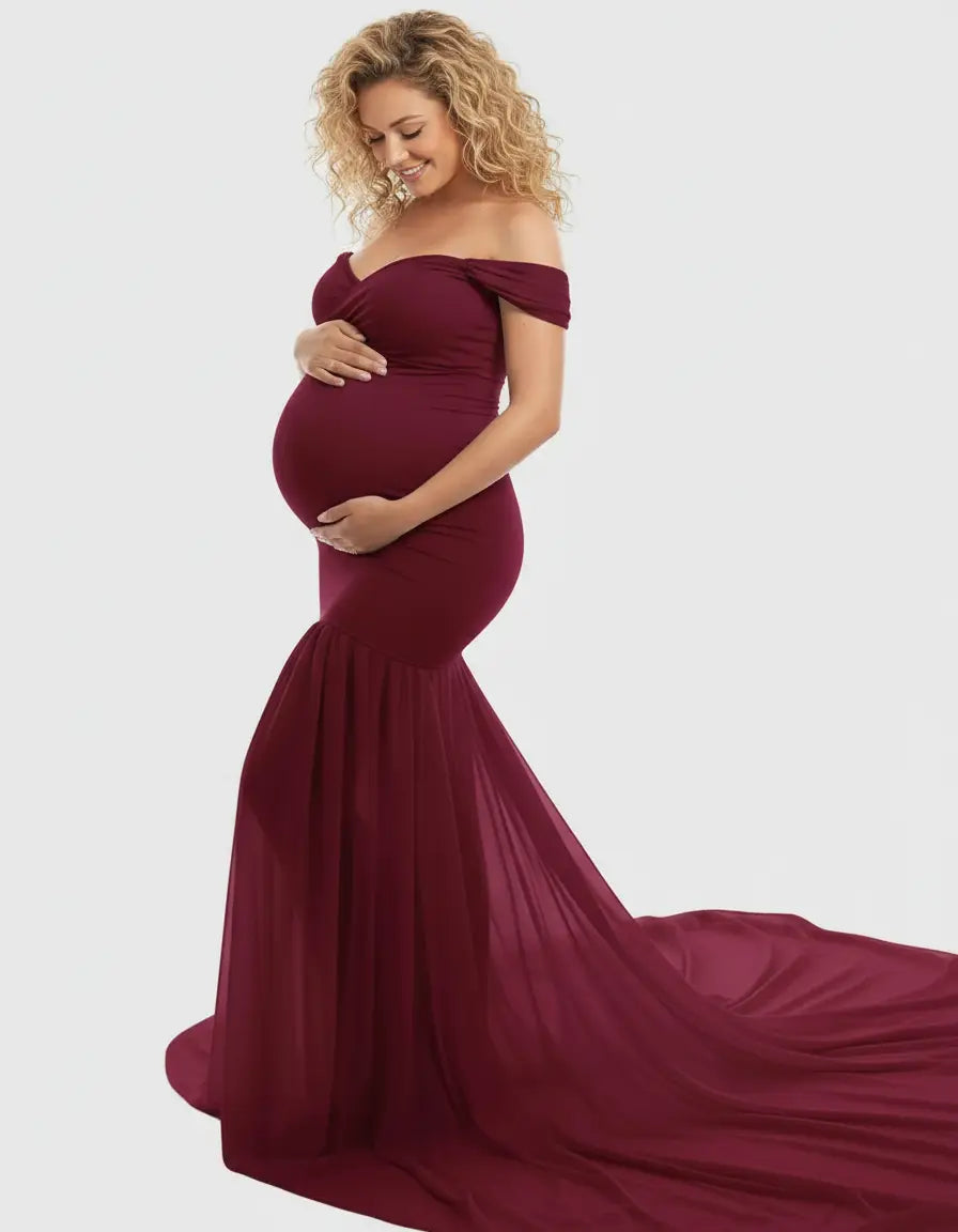 Off-shoulder flowy maternity gown in a deep burgundy, with a form-fitting bodice and a long, flowing skirt.