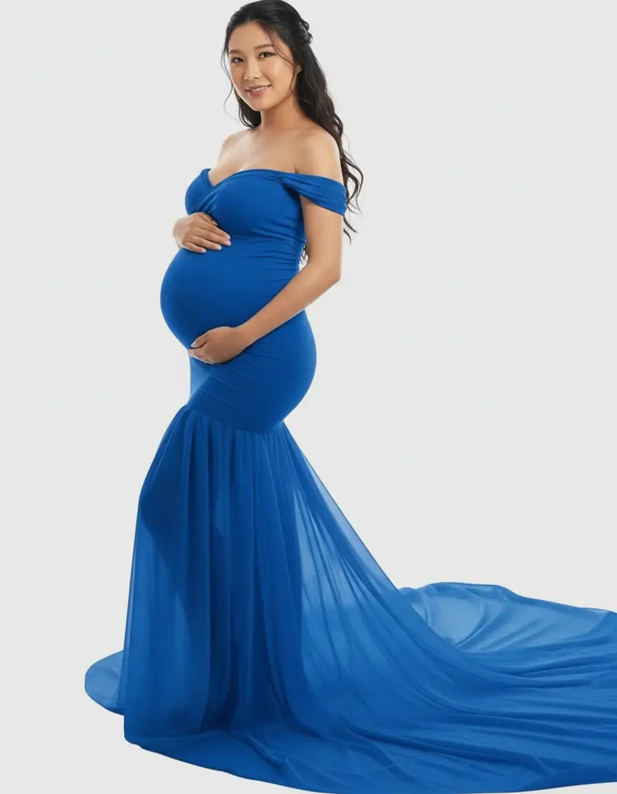 Smiling pregnant woman in a royal blue off-shoulder maternity gown with a flowing chiffon train.