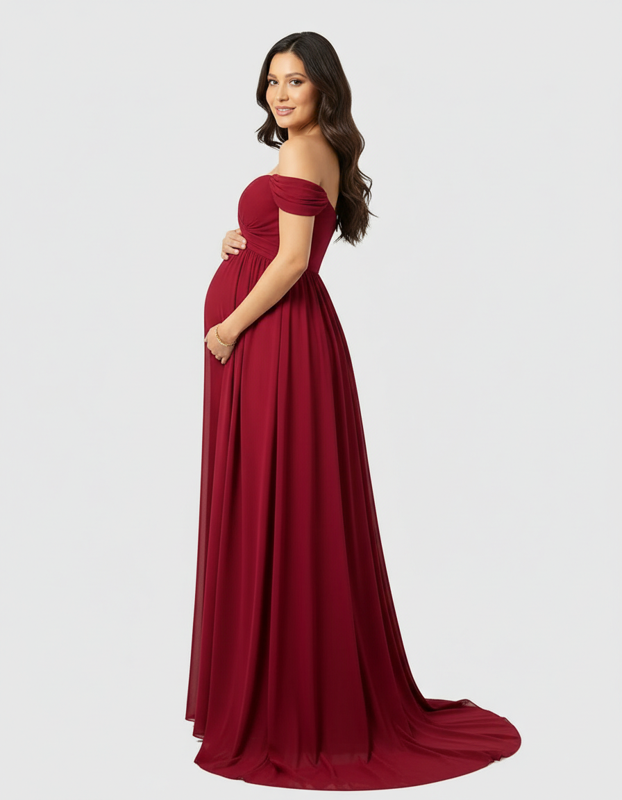 Pregnant woman in a flowing, off-shoulder, laced burgundy maternity maxi dress with a long train.
