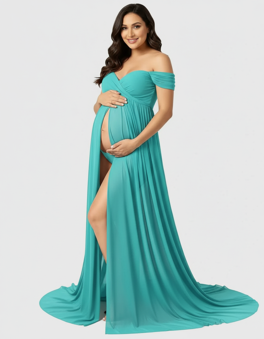 Smiling pregnant woman in a teal off-shoulder flowing maternity maxi dress with a front slit.