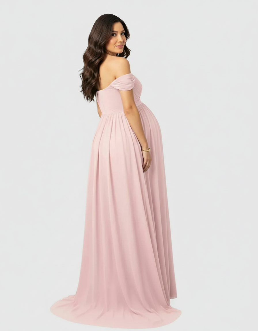 Maternity maxi dress in soft pink, off-shoulder with a flowing skirt, worn by a pregnant woman.