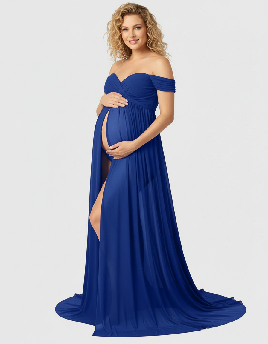 Smiling pregnant woman in a flowing royal blue off-shoulder maternity maxi dress with a thigh-high slit.