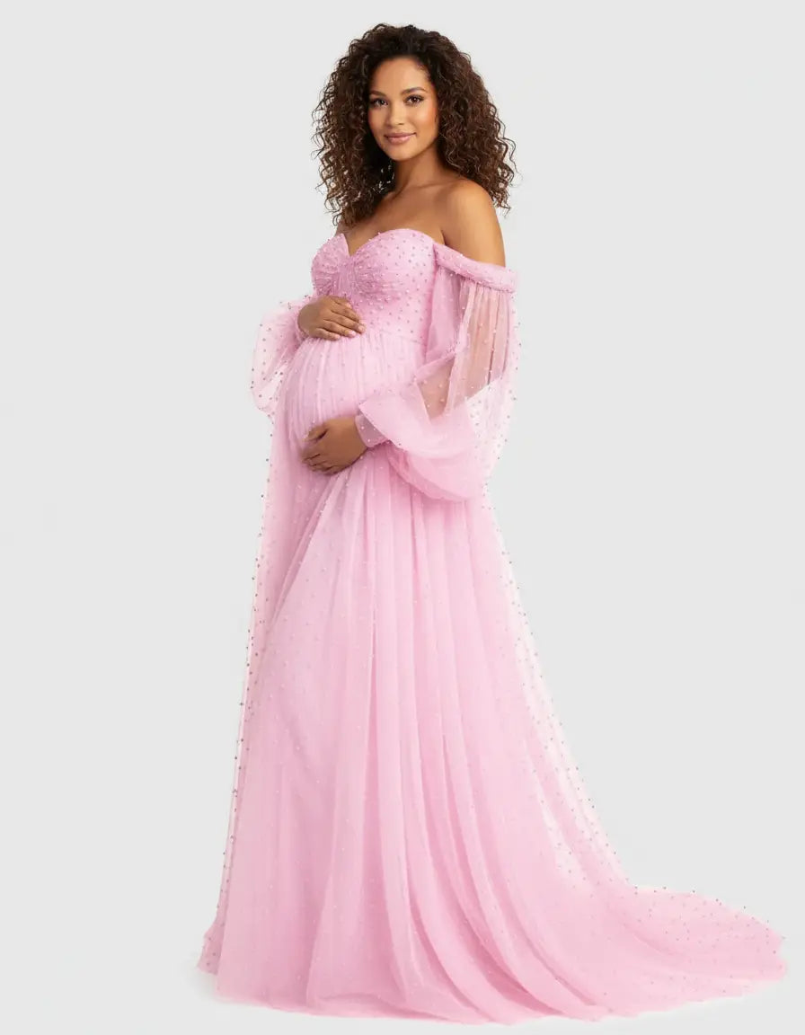 Pregnant woman in a pink off-shoulder tulle train maternity gown with pearl details.
