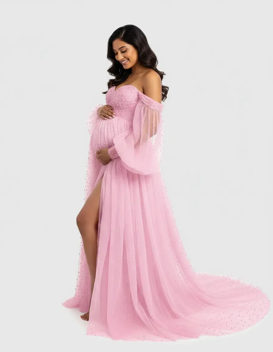Smiling pregnant woman in a pink off-shoulder tulle train maternity gown with pearl details and a high slit.