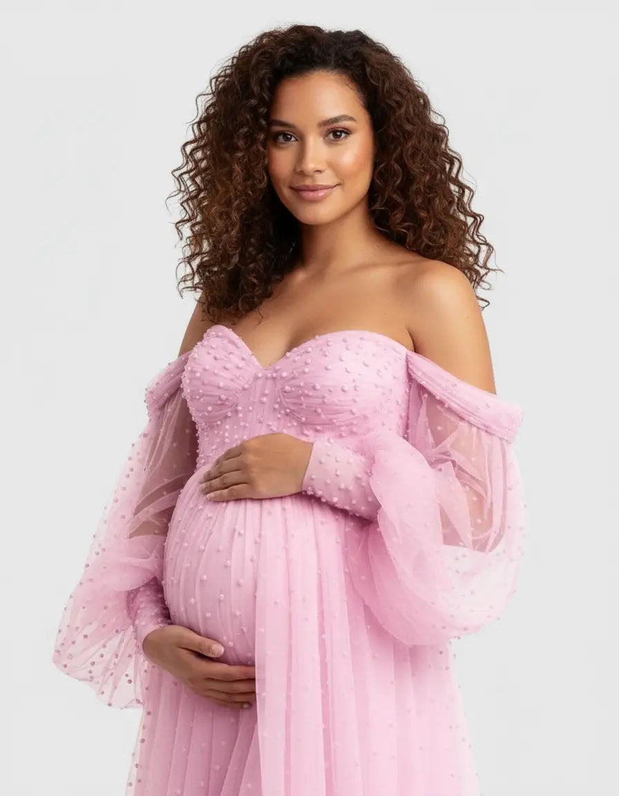 Pregnant woman in a pink off-shoulder tulle train maternity gown with textured polka dots.