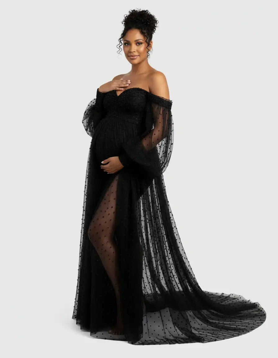Black off-shoulder tulle train maternity gown with sheer polka dot sleeves and skirt slit.