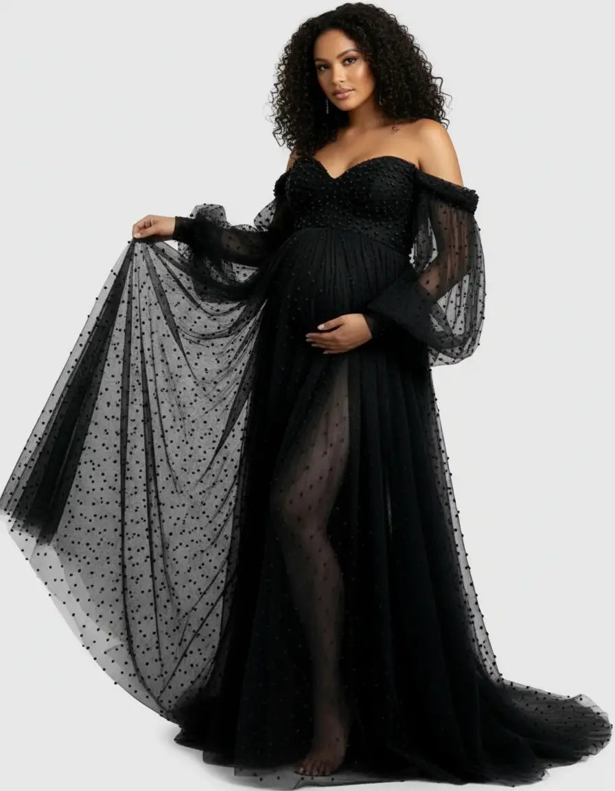 Black off-shoulder tulle train maternity gown with polka dots, long sheer sleeves, and a thigh-high slit.