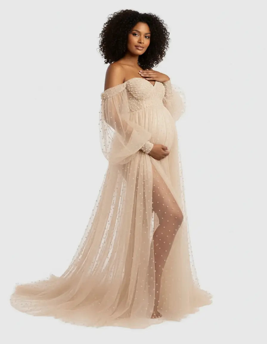 Off-shoulder tulle train maternity gown in champagne with pearl embellishments and a high slit.