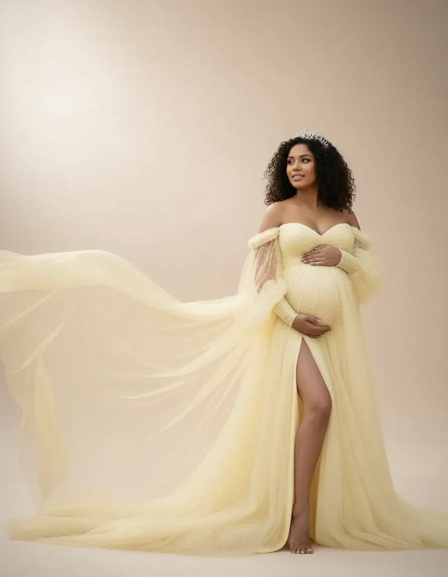 Pregnant woman in an off-shoulder, light yellow tulle train maternity gown with a thigh-high slit.